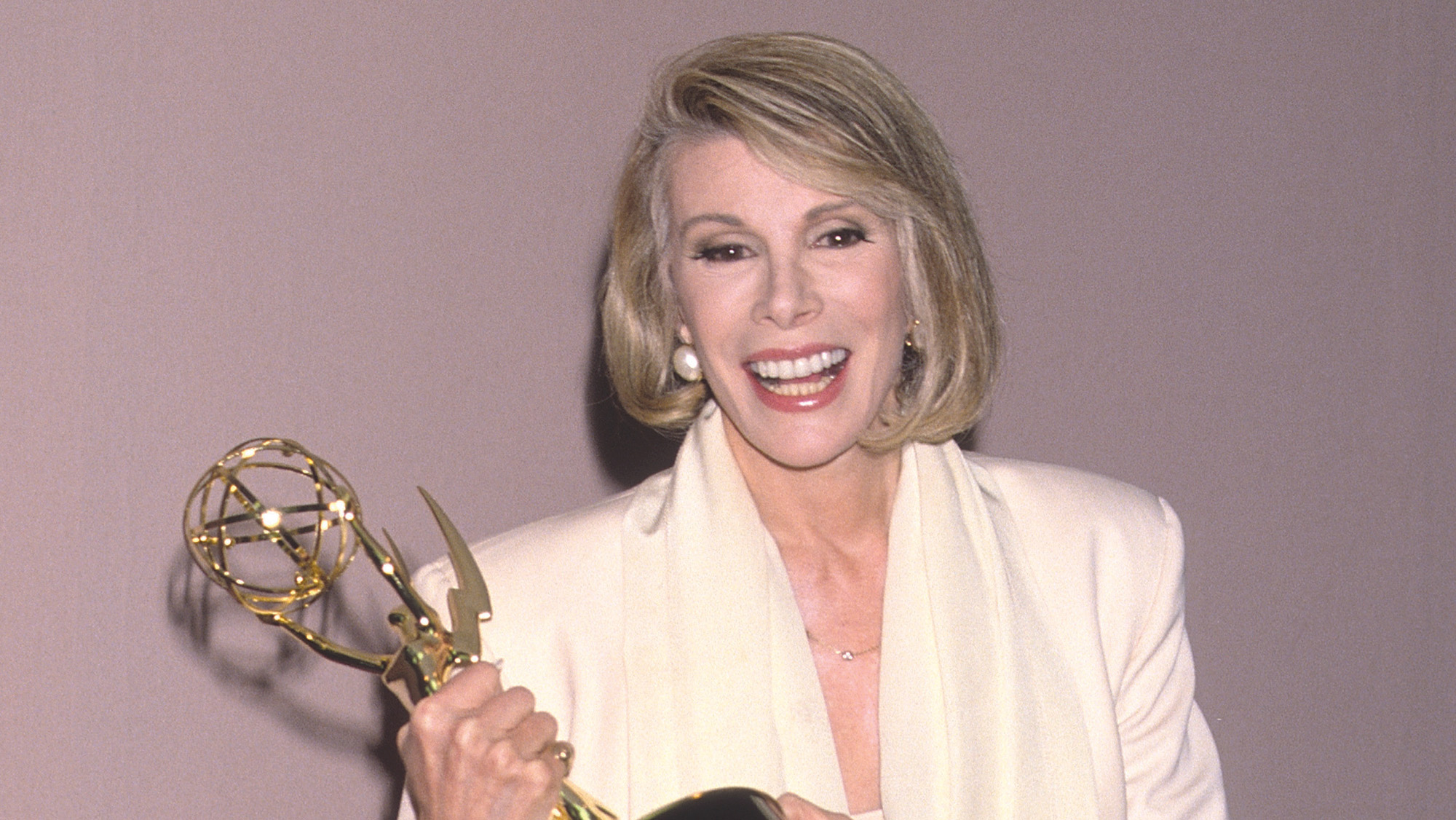 Joan Rivers holding an Emmy statuette