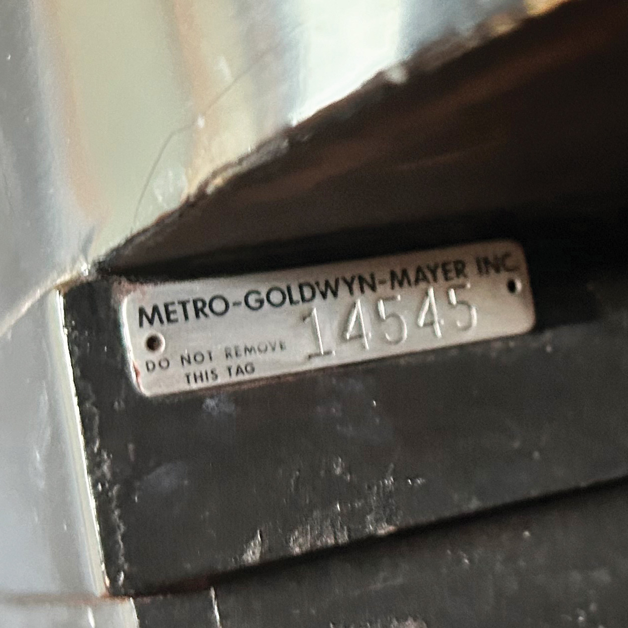 the metal tag on a piano reading "METRO-GOLDWYN-MAYER INC. 14545"